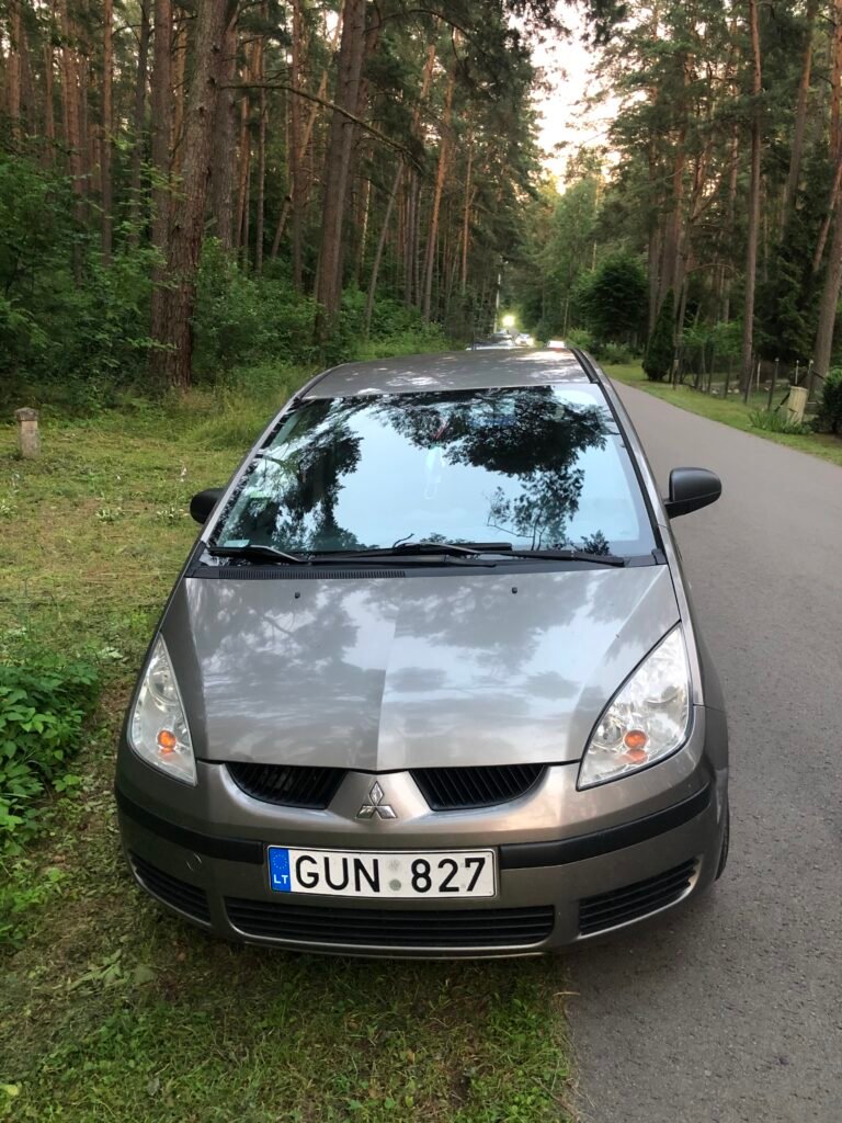 Automobilių supirkimas Pakruojyje: pilkas Mitsubishi Colt automobilis stovintis prie miško Pakruojo rajone.