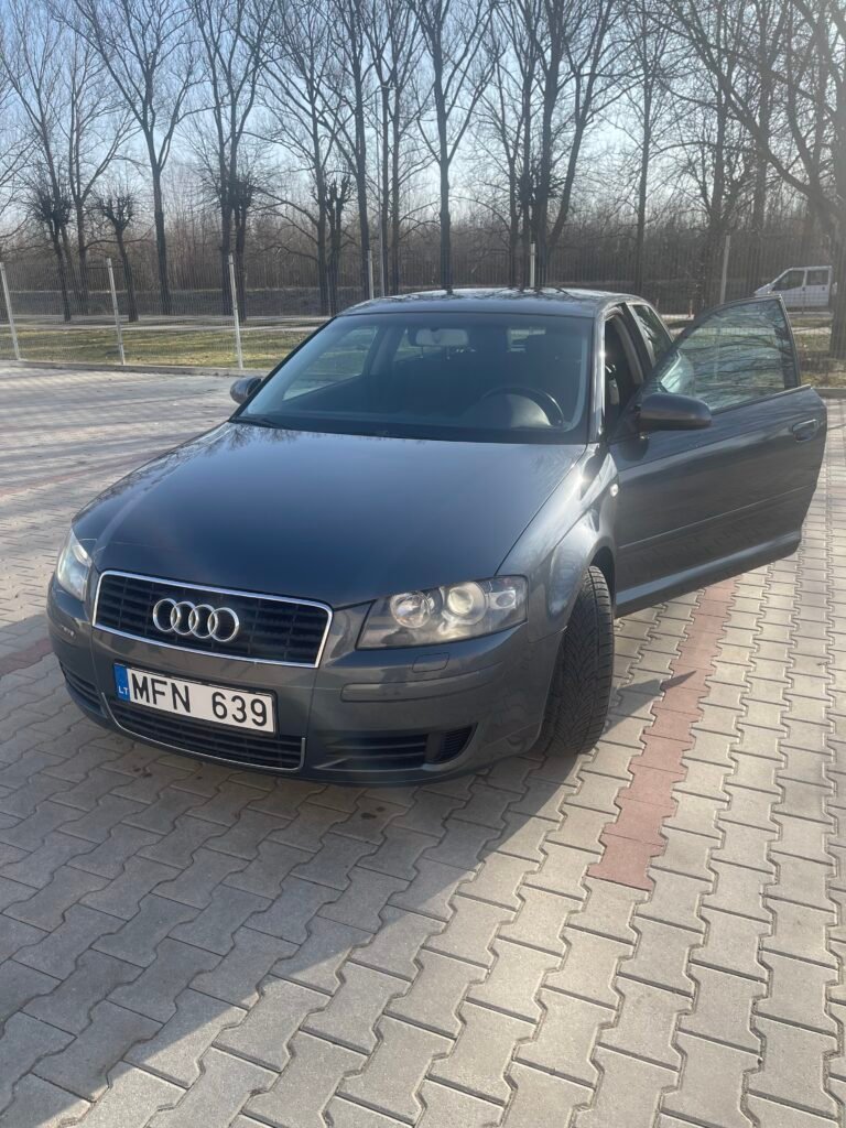 Tamsiai pilkas, tvarkingas Audi A3 Sportback hečbekas automobilių aikštelėje atidarytomis durimis. Brangus Audi supirkimas.