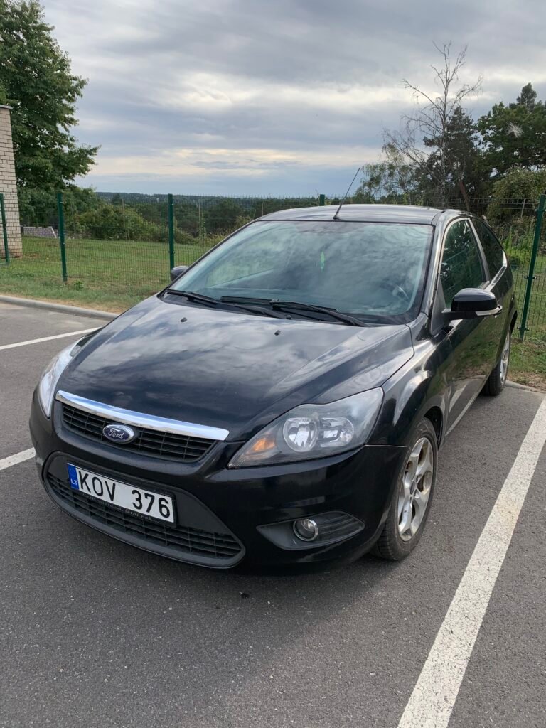 Juodas Ford Focus hečbekas automobilių aikštelėje. Naudotų automobilių supirkimas Pakruojyje, AutoDylas.