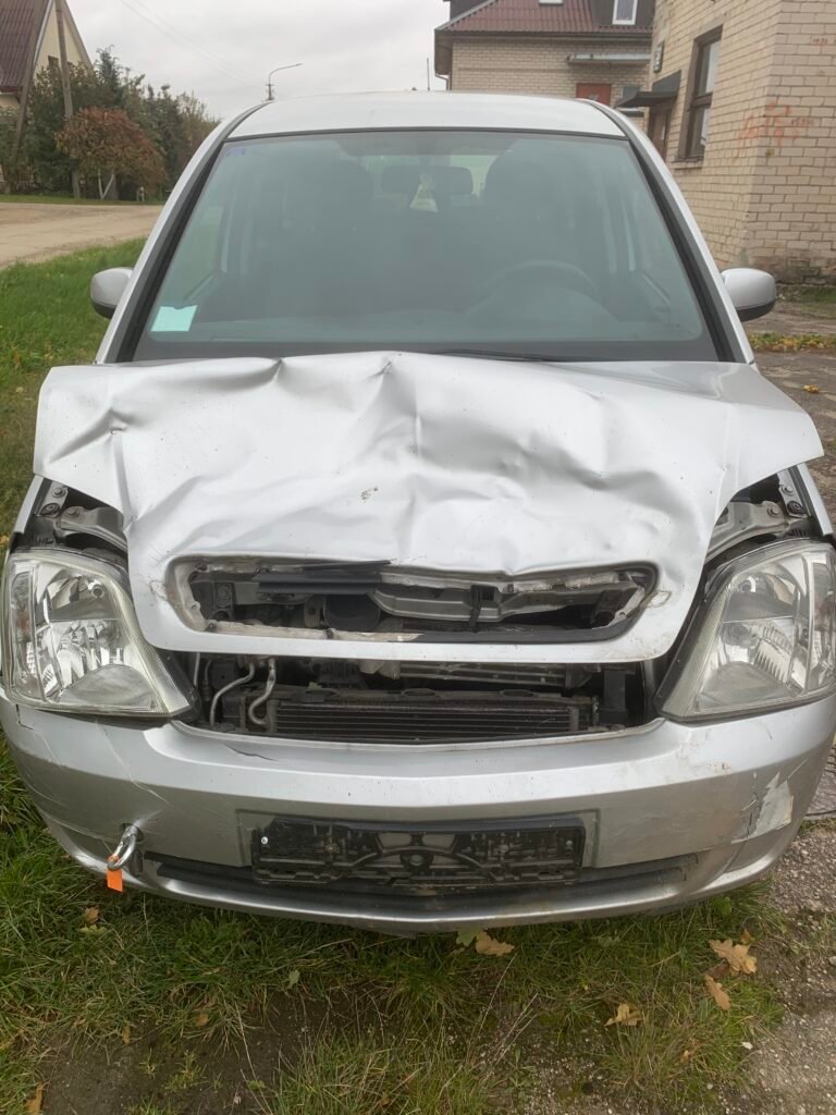 Sidabrinis automobilis su iššovusiomis oro pagalvėmis ir sudaužytu priekiniu žibintu po avarijos.
