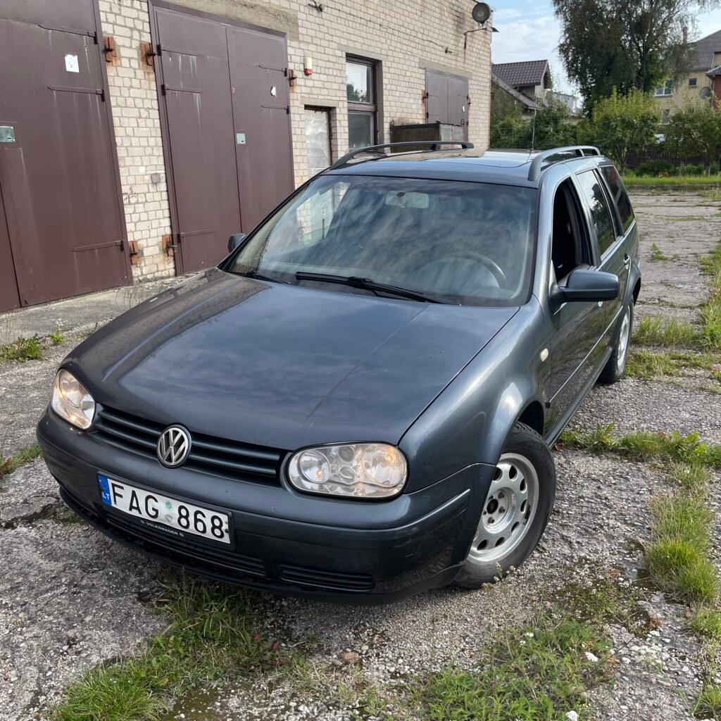 Perkame automobilius be tech apžiūros – tamsus VW Golf universalas prie garažų